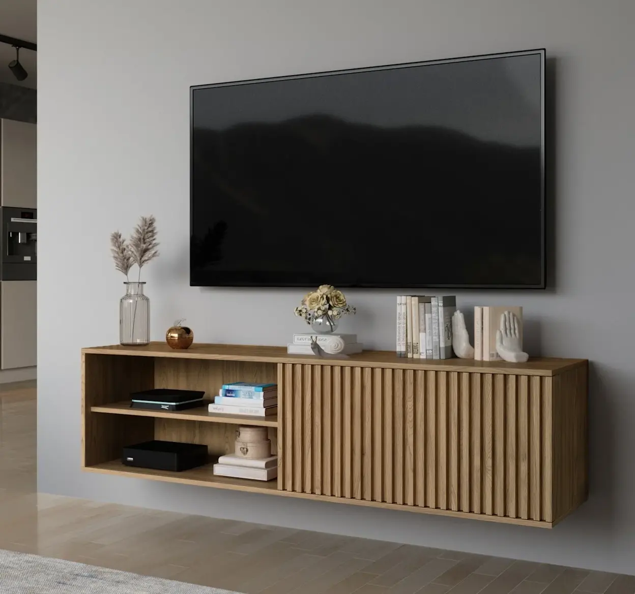 Wiszaca szafka RTV Entsian z drewnianymi lamelami, ustawiona pod telewizorem w jasnym salonie, ozdobiona książkami i minimalistycznymi dekoracjami.