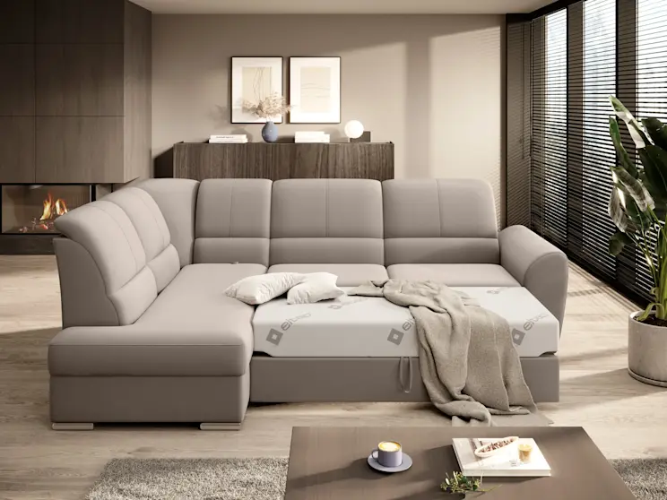 Komfortowy narożnik Siber w neutralnym odcieniu, z rozłożoną powierzchnią spania, prezentowany w przytulnym, minimalistycznym wnętrzu.