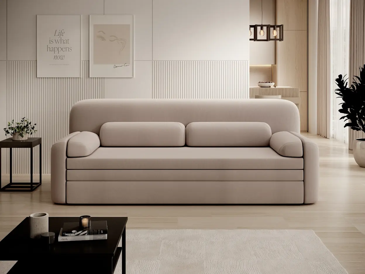 Aranżacja salonu z beżową kanapą Elioss Sola 18 o obłych kształtach i niskiej podstawie. Na pierwszym planie znajduje się czarny stolik kawowy Lanzzi, a w tle widać ścianę z pionowymi frezami oraz lampę wiszącą Giorri