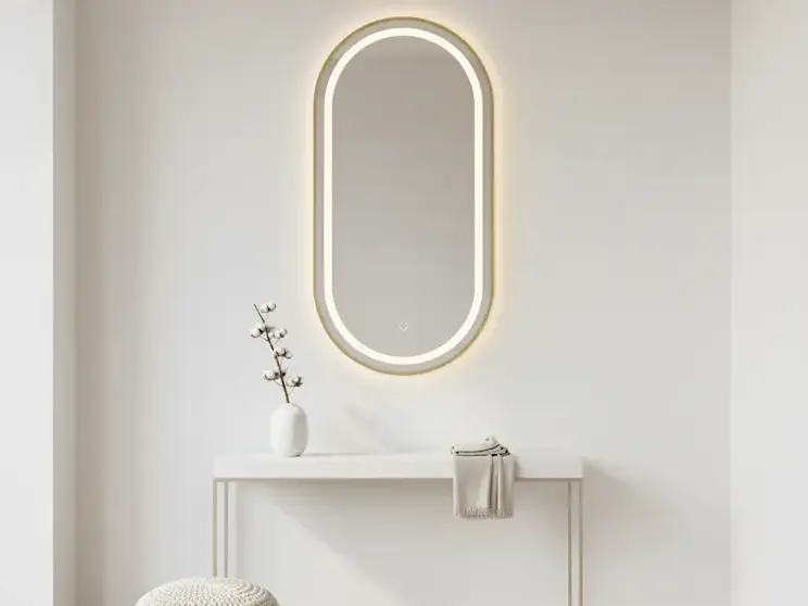 Owalne lustro Micedi L z podświetleniem LED zamontowane nad konsolą w jasnym przedpokoju, z dekoracyjnym wazonem i minimalistycznymi dodatkami, tworzące elegancką i nowoczesną aranżację wnętrza.