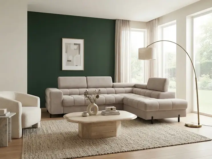 Narożnik Ferucce w jasnej tapicerce został ustawiony w nowoczesnym salonie z dużymi przeszkleniami. Pikowane siedziska i minimalistyczna forma nadają wnętrzu elegancki charakter.