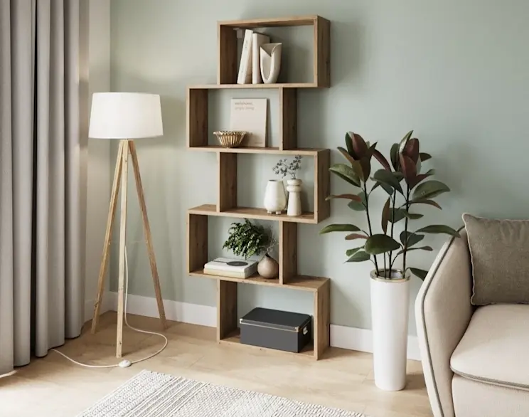 Regał Shellf w dekorze drewna z półkami na książki i dekoracje, ustawiony przy zielonej ścianie obok rośliny i lampy stojącej.
