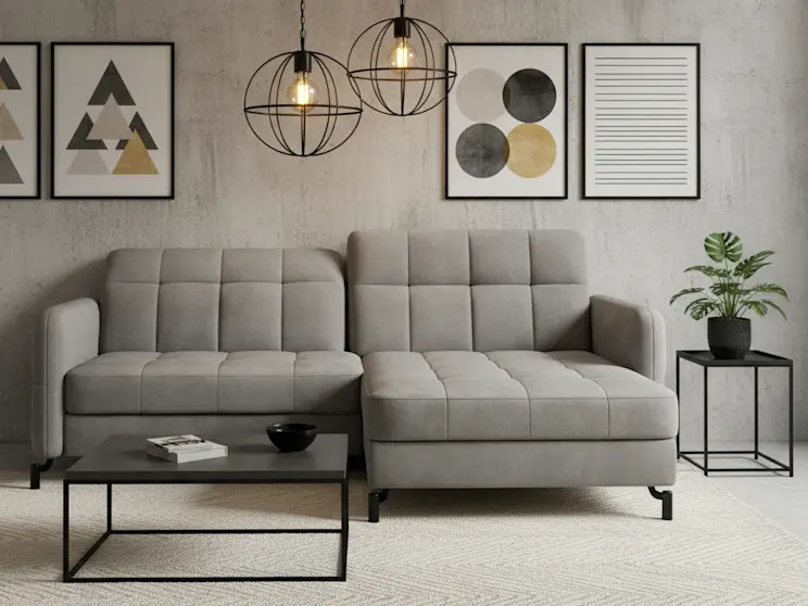 Narożnik Lorelle w tkaninie Monolith 84 ustawiony w minimalistycznej aranżacji z betonową ścianą, rośliną i geometrycznymi obrazami.