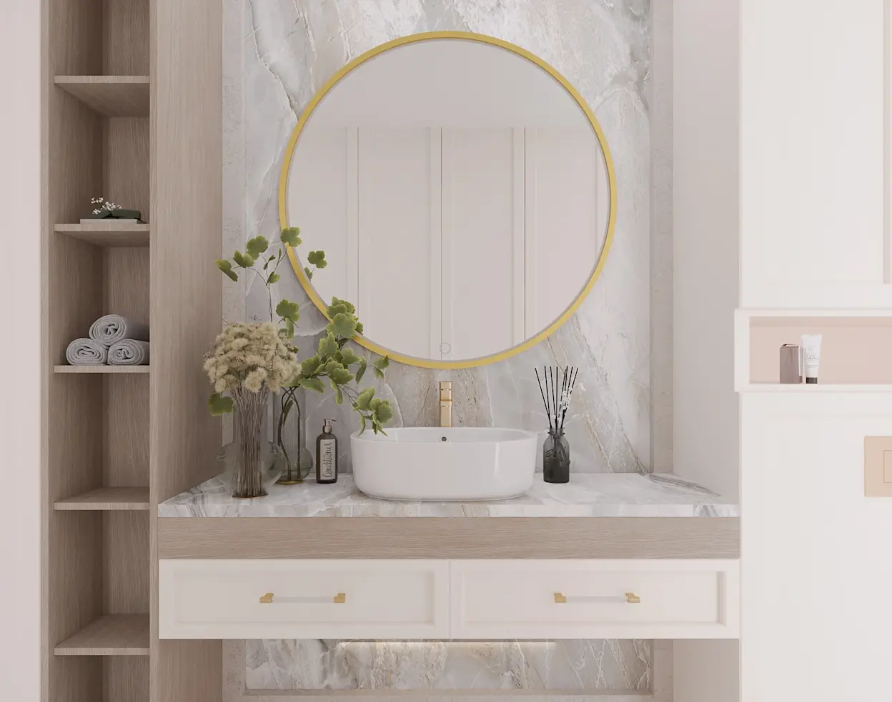 Okrągłe lustro wiszące na ścianę Gerbinie w złotej ramie w eleganckiej łazience. Nad białą umywalką nablatową i jasnym blatem widać marmurową okładzinę, a obok stoją dekoracje oraz półki na ręczniki.