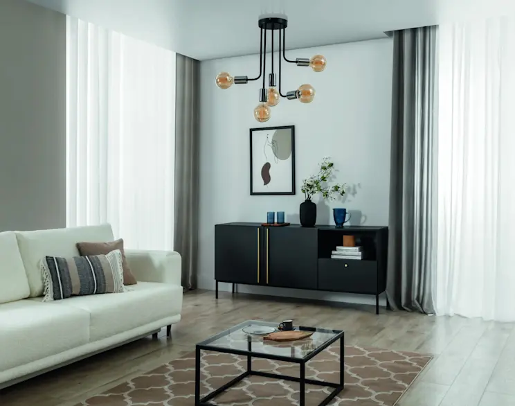 Nowoczesny salon z jasną sofą, czarną komodą i minimalistycznym oświetleniem sufitowym w industrialnym stylu.