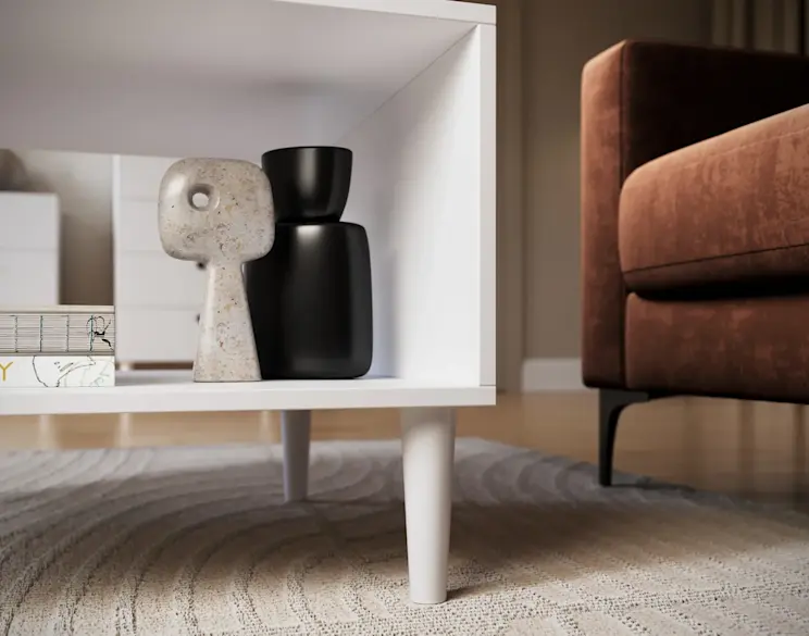 Biały stolik kawowy Dullum z praktyczną półką, ozdobiony nowoczesnymi dekoracjami, ustawiony we wnętrzu z brązową sofą i jasnym dywanem.