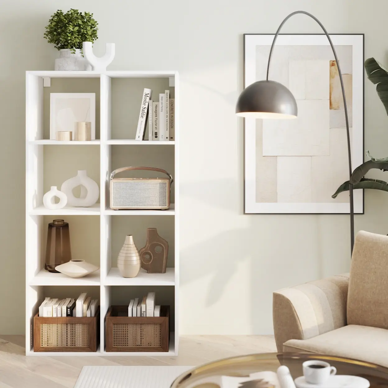Biały regał Postto z otwartymi półkami w jasnym salonie, na półkach książki, ceramika i dekoracje. Obok stoi lampa podłogowa z łukowym ramieniem, a całość tworzy elegancką, uporządkowaną strefę dzienną.