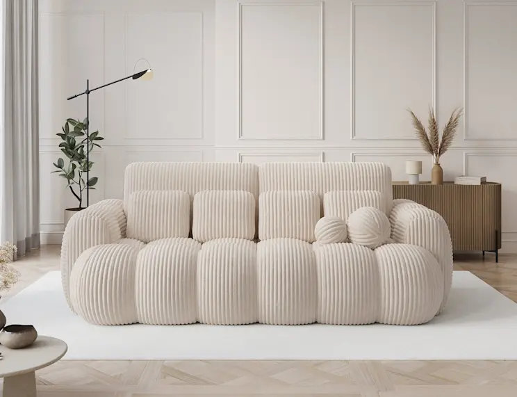 Nowoczesna sofa Cotonn w tkaninie Modullo 01, ustawiona na białym dywanie w jasnym, eleganckim wnętrzu w stylu modern classic.