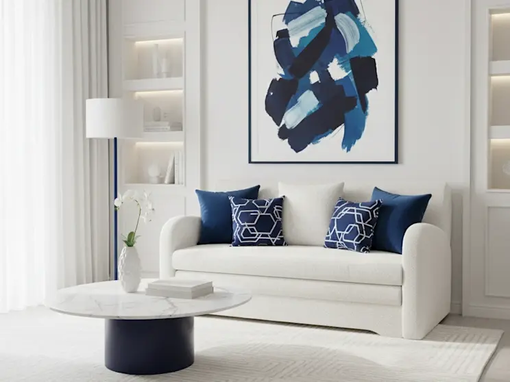 Biała sofa Ario w tkaninie boucle Royal 01, zaprezentowana w eleganckim salonie z granatowymi dodatkami i nowoczesną sztuką na ścianie.