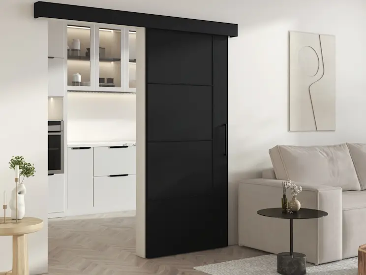 Drzwi Crestina przesuwne w kolorze czarnym z poziomymi panelami i uchwytem, zamontowane w szerokim przejściu. Aranżacja pokazuje praktyczne rozwiązanie do strefowania salonu i kuchni bez zabierania przestrzeni.