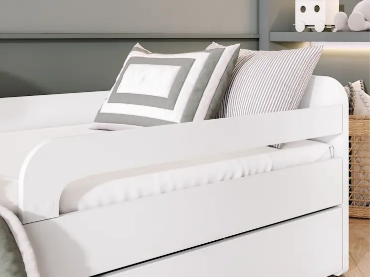 Detal łóżka Duuli z materacem do pokoju dziecka – ujęcie na boczną barierkę ochronną i wygodny materac. Minimalistyczna forma i białe wykończenie pasują do nowoczesnych, jasnych aranżacji.