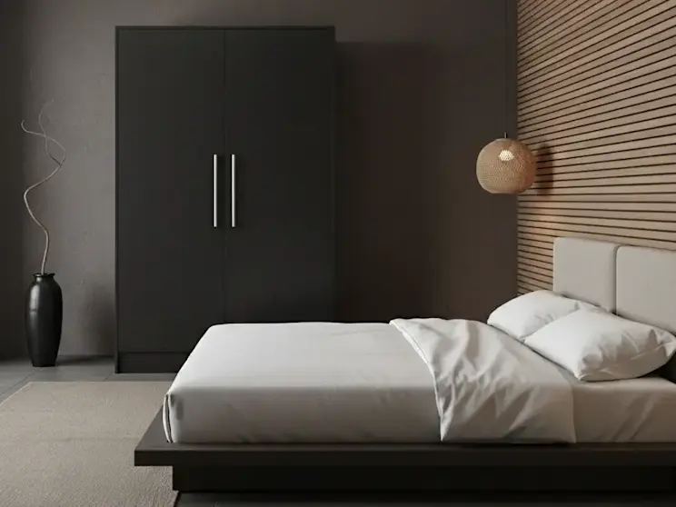 Szafa Alarica II w kolorze czarnym ustawiona w stylowej sypialni z industrialnymi akcentami, takimi jak ciemne ściany, proste formy i naturalne drewno. Mebel podkreśla nowoczesny charakter wnętrza i jego uporządkowaną estetykę.