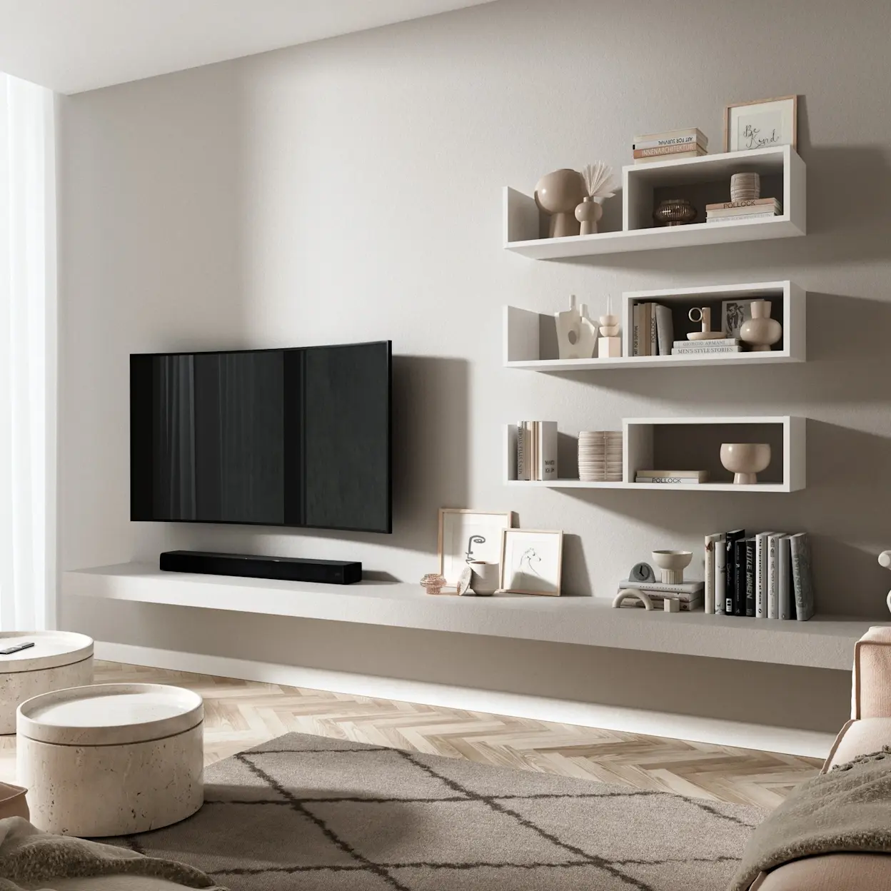 Biała półka Vellia w formie zestawu modułów ściennych nad strefą RTV w nowoczesnym salonie. Na półkach stoją książki i dekoracje, a pod nimi widać telewizor oraz długą, minimalistyczną zabudowę.