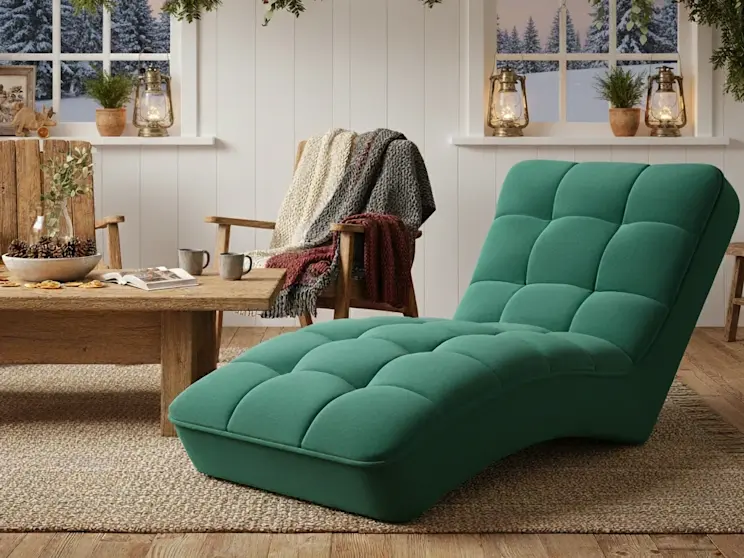 Szezlong Loren Nube 35 w głębokiej zieleni ustawiony w zimowym, przytulnym salonie z drewnianymi meblami, girlandą i widokiem na ośnieżony krajobraz.