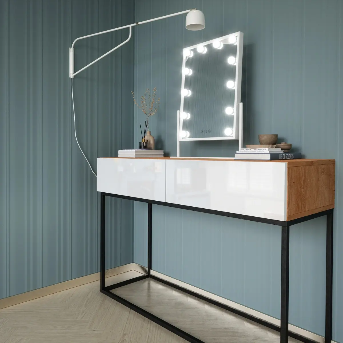 Kącik toaletkowy z lustrem Flamnate – biała rama z okrągłymi żarówkami zapewnia równomierne światło do makijażu. Lustro stoi na nowoczesnej komodzie w białym połysku z drewnianym blatem i metalowym stelażem, przy lamelowej ścianie.