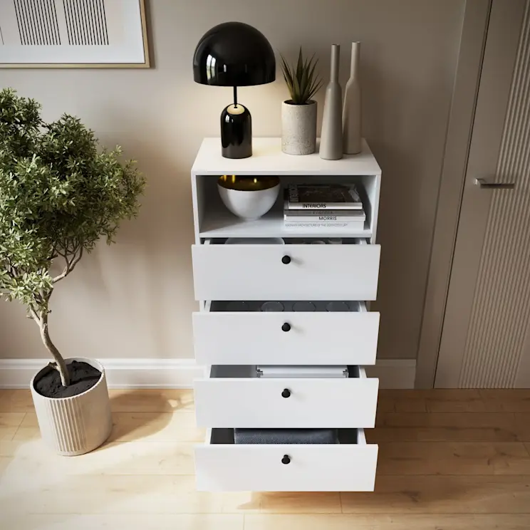 Biały regał Dullum z czterema wysuniętymi szufladami i dekoracjami na blacie, ustawiony w jasnym, nowoczesnym wnętrzu z rośliną w donicy.