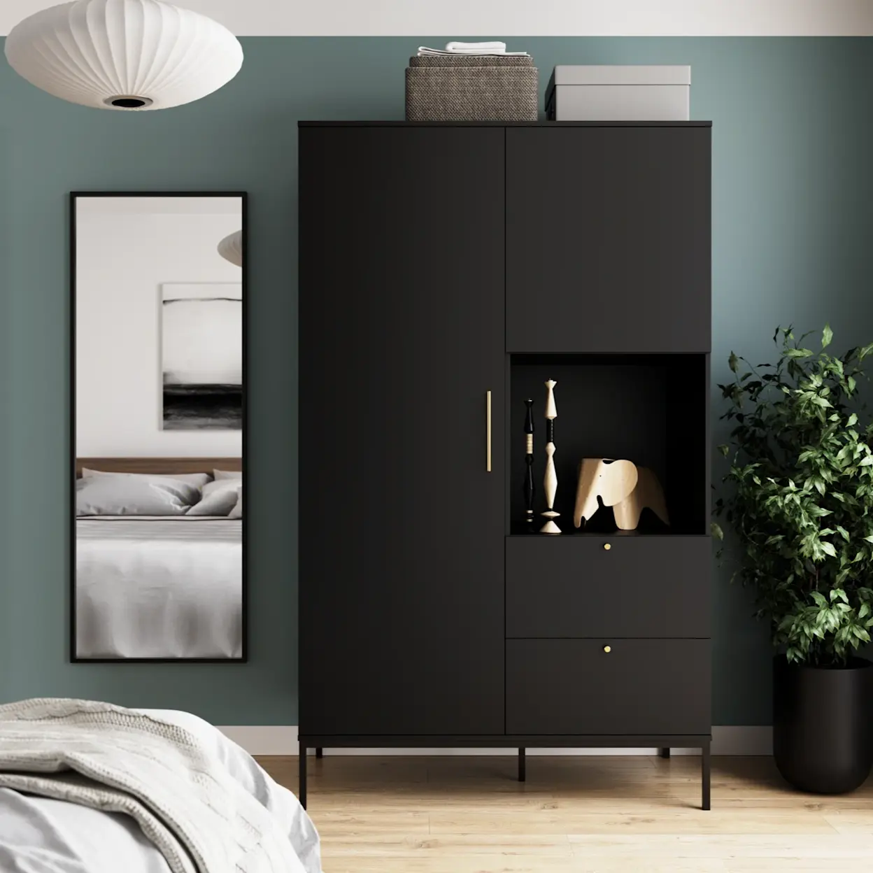 Aranżacja sypialni z szafą Lanzzi w czarnym wykończeniu na smukłych nóżkach. Widoczna jest otwarta półka z dekoracjami oraz szuflady, a lustro Medina optycznie powiększa przestrzeń i odbija fragment łóżka w tle.