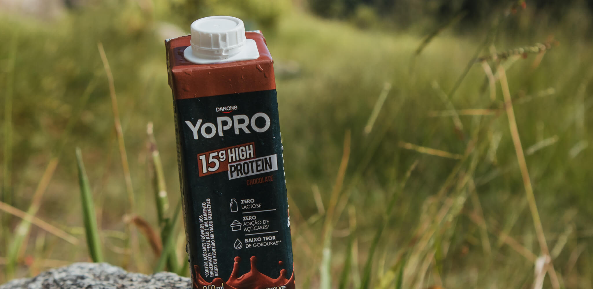 Bebida YoPRO com vegetação no fundo