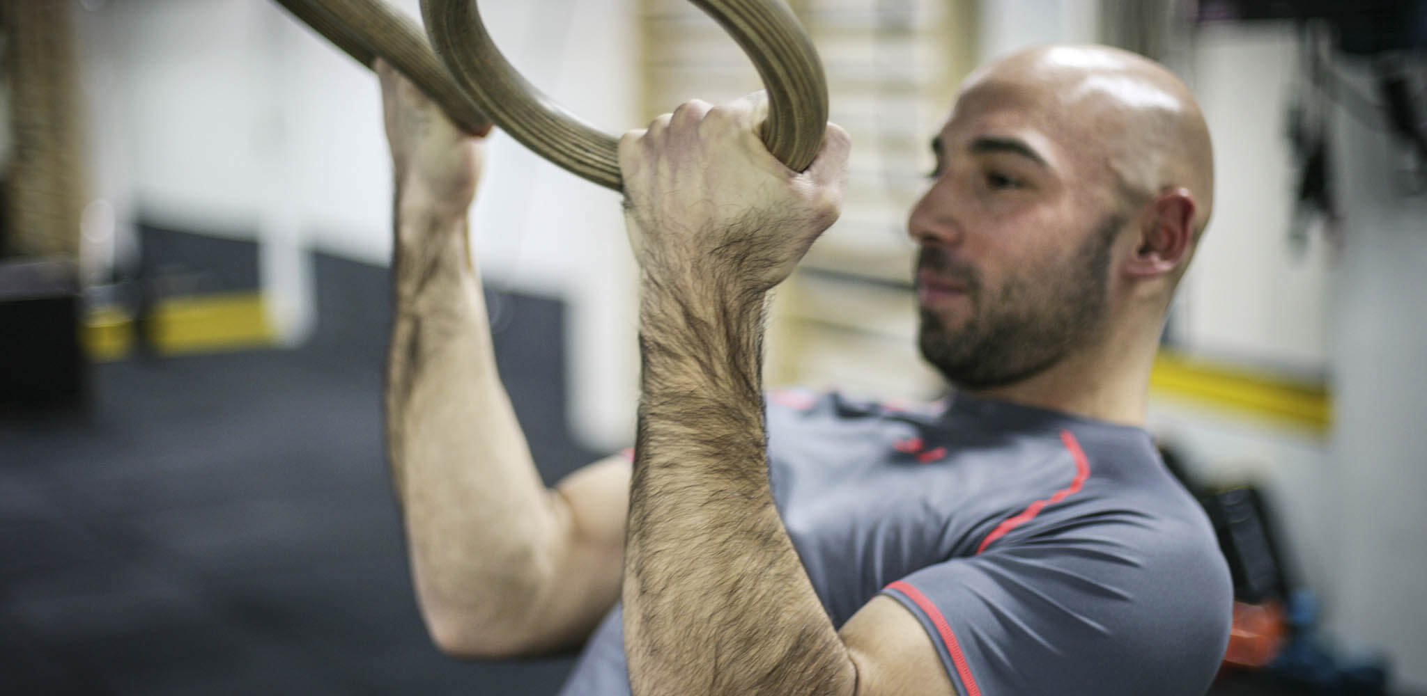 Homem faz exercícios com argolas na academia