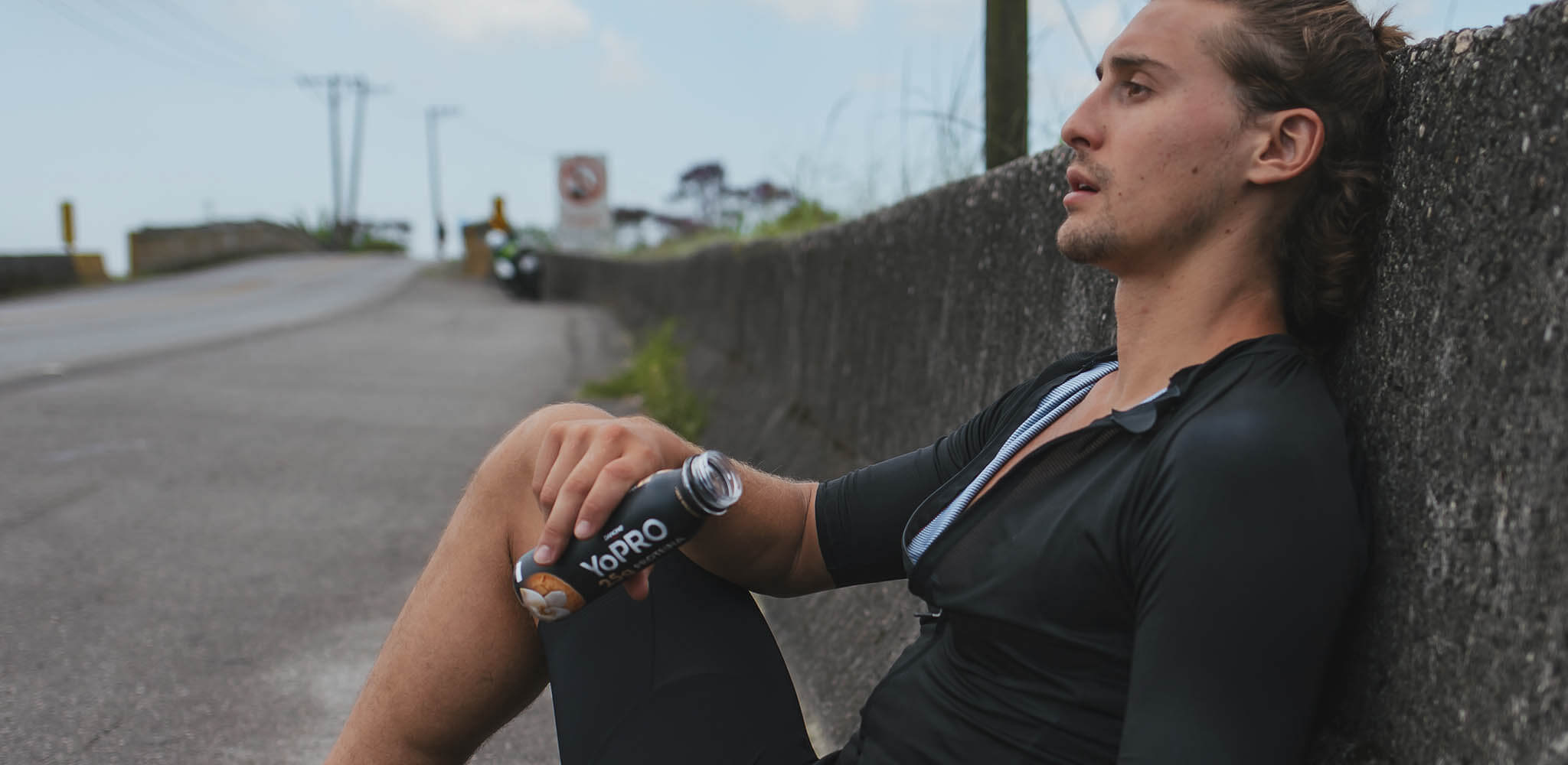 Homem consome YoPRO enquanto descansa em treino de corrida