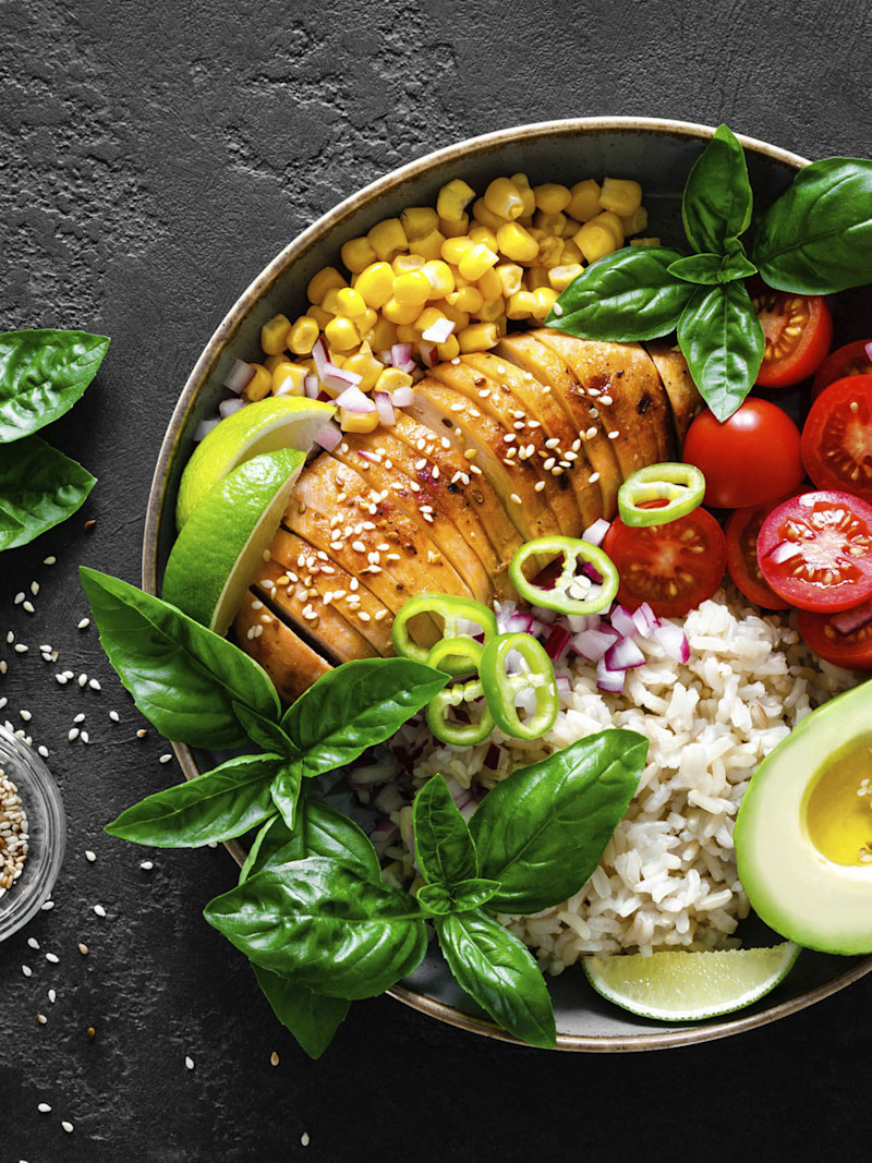 Prato de refeição com carne magra fatiada, folhas verdes, arroz e milho verde