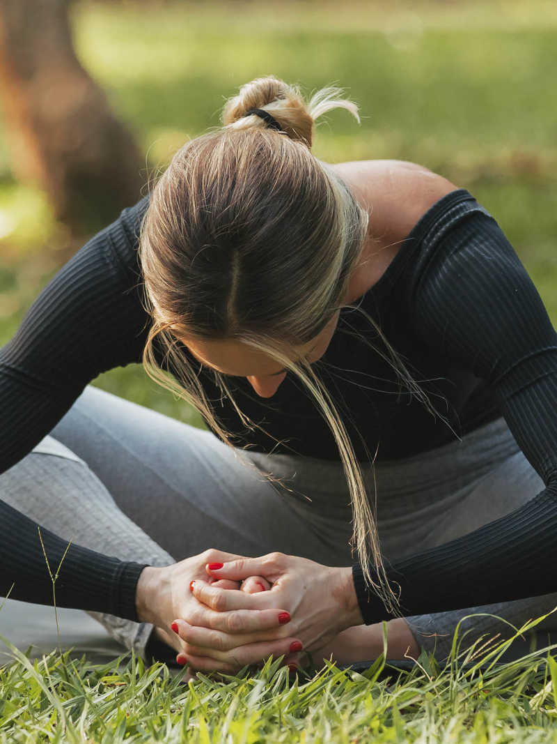 Mulher pratica yoga em parque