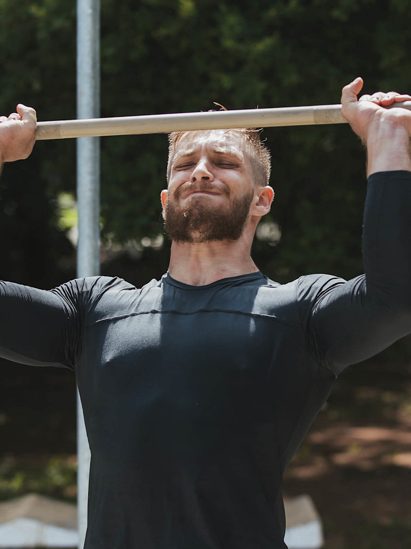 Homem faz exercício com barra
