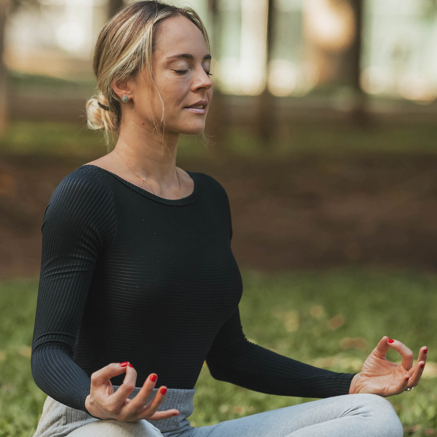 Mulher faz meditação em parque