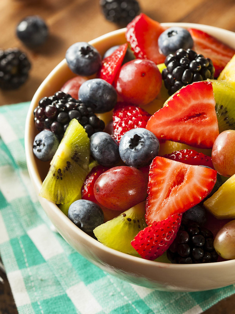 Salada de frutas em um pote sobre mesa com toalha xadrez