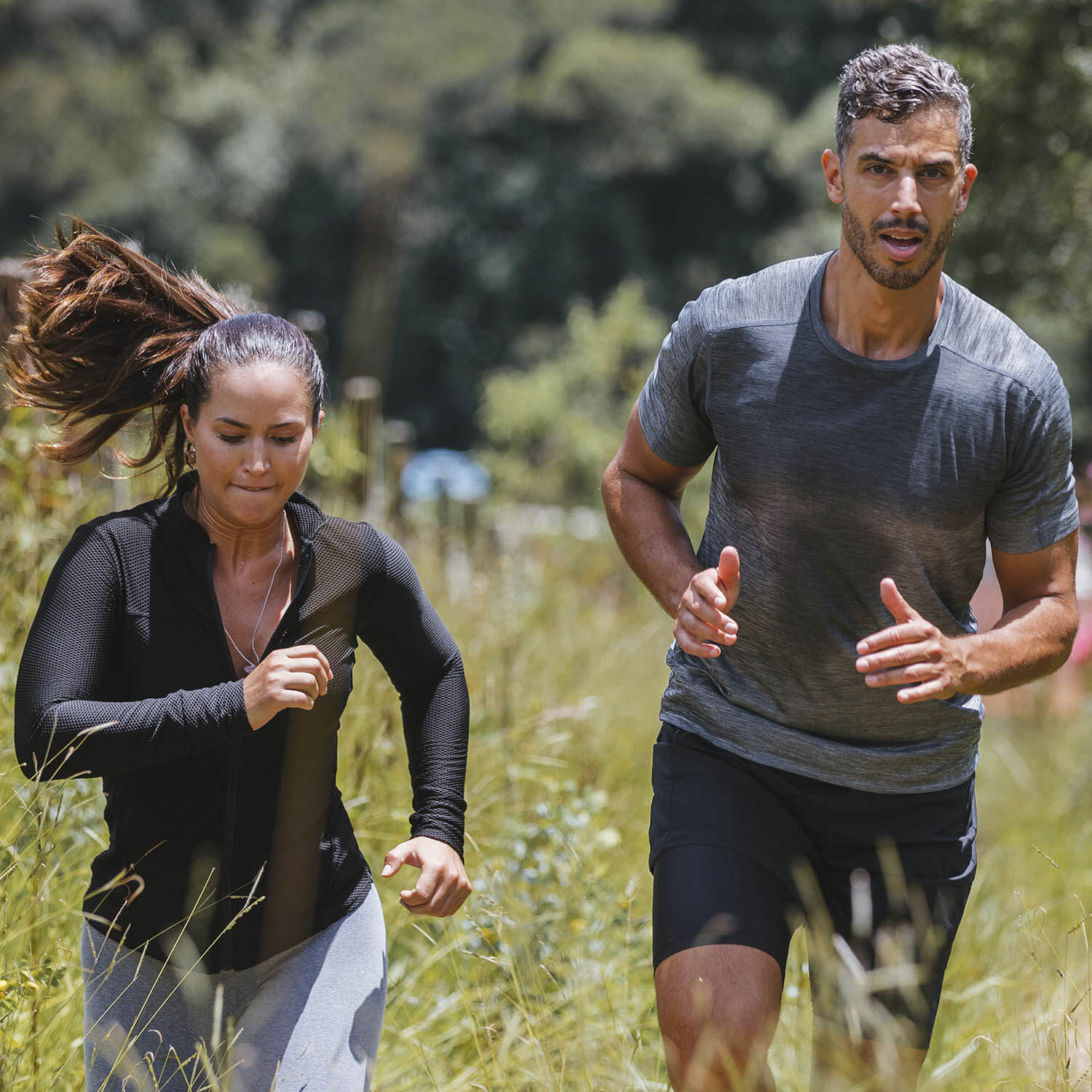 Homem e mulher praticam corrida em meio à natureza