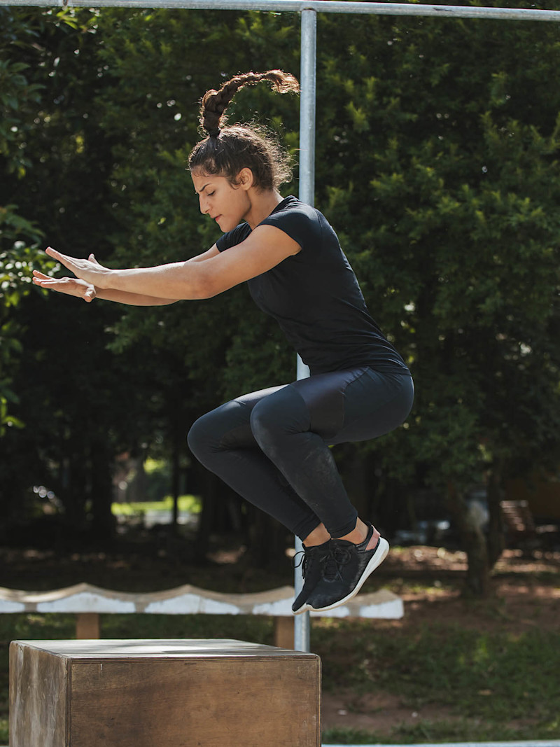 Mulher faz salto durante treino