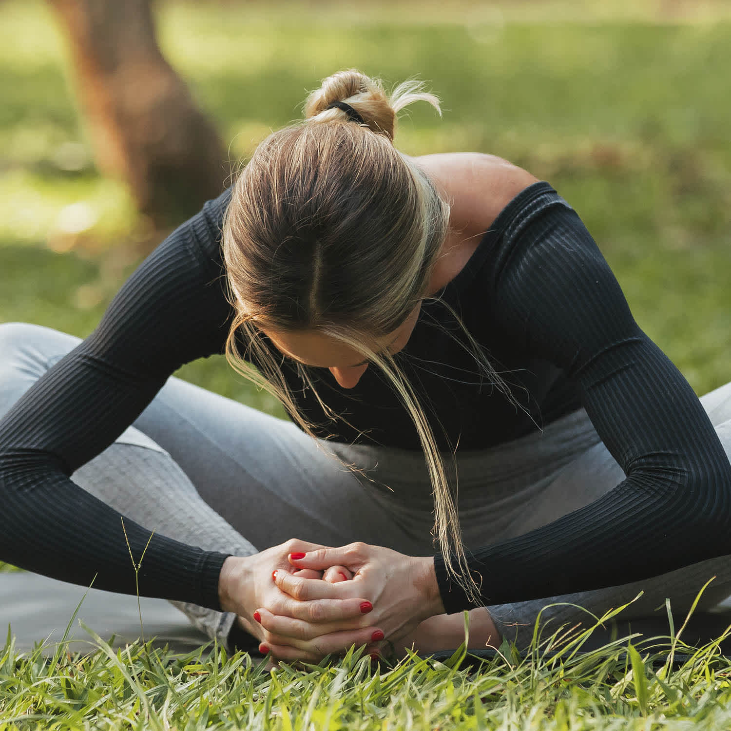Mulher pratica yoga em parque