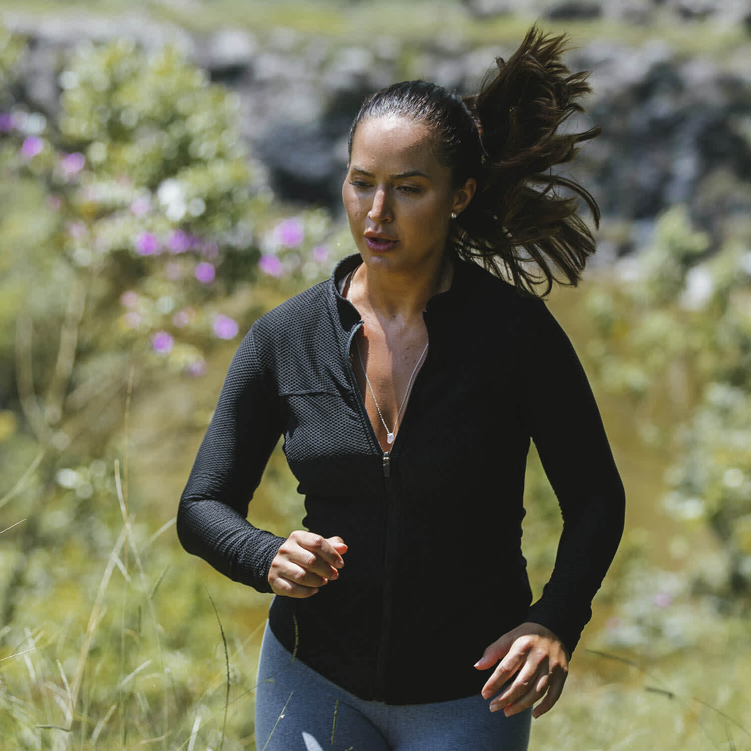 Mulher corre em meio à natureza