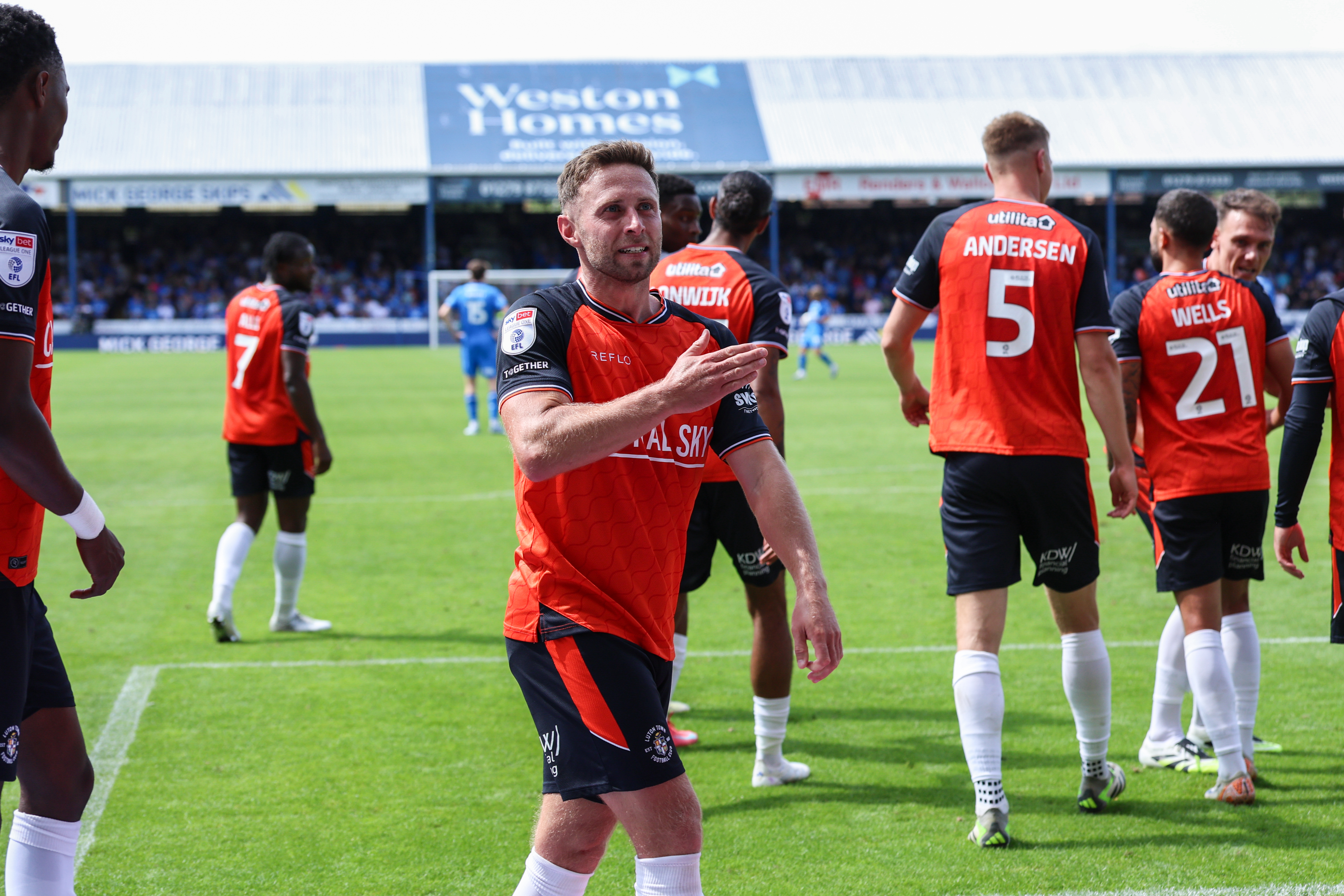 Jordan Clark celebrates his goal in the 2-0 win at Peterborough by beating the Luton badge on his shirt.