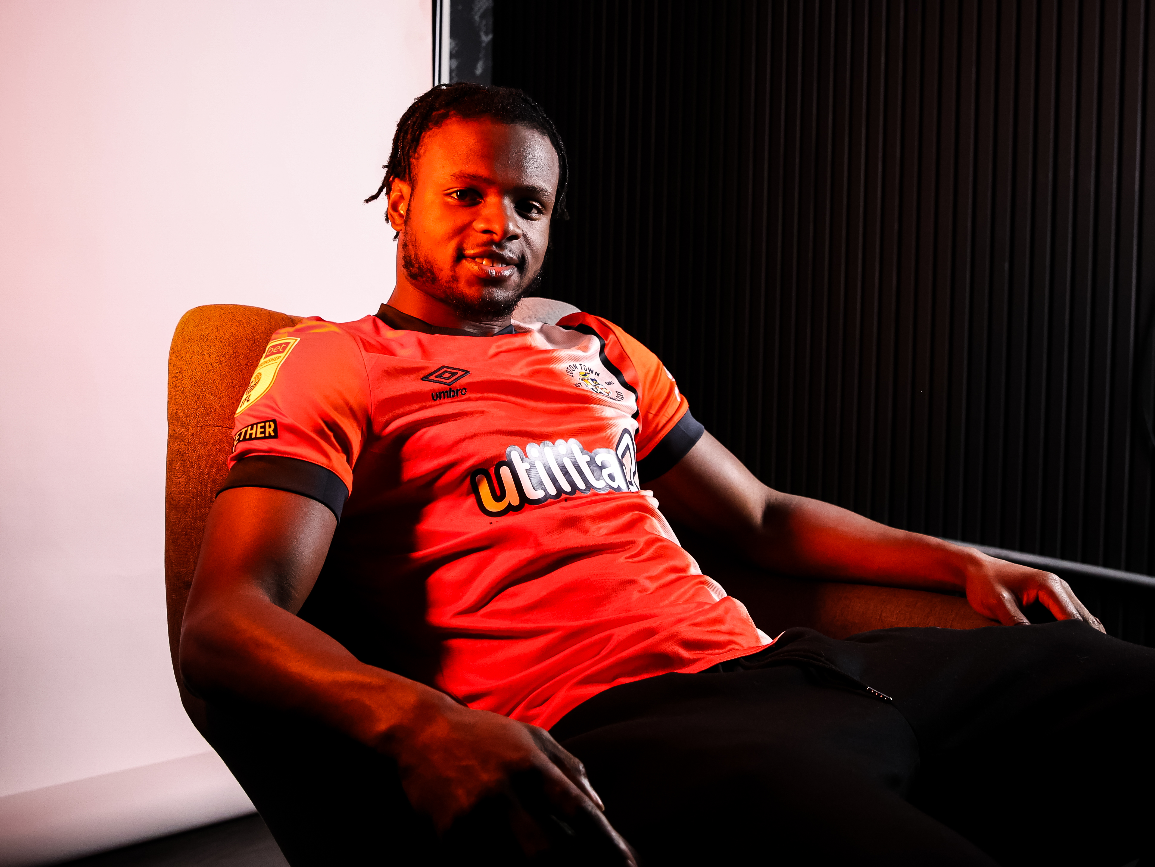 Millenic Alli relaxes in a chair during the photoshoot to announce his signing for Luton Town from Exeter City.