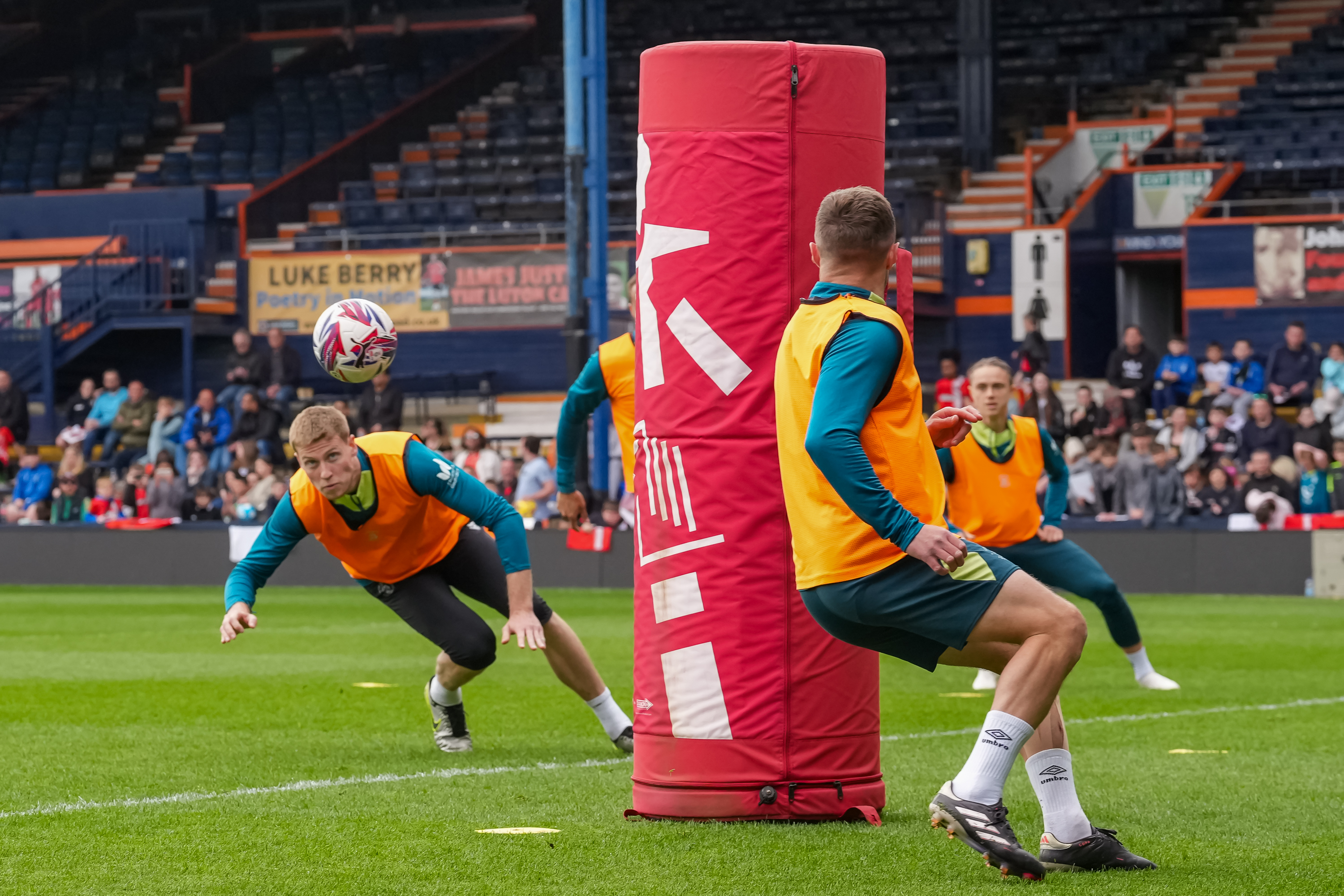 Mark McGuinness goes in for a diving header in the open training session at Kenilworth Road.