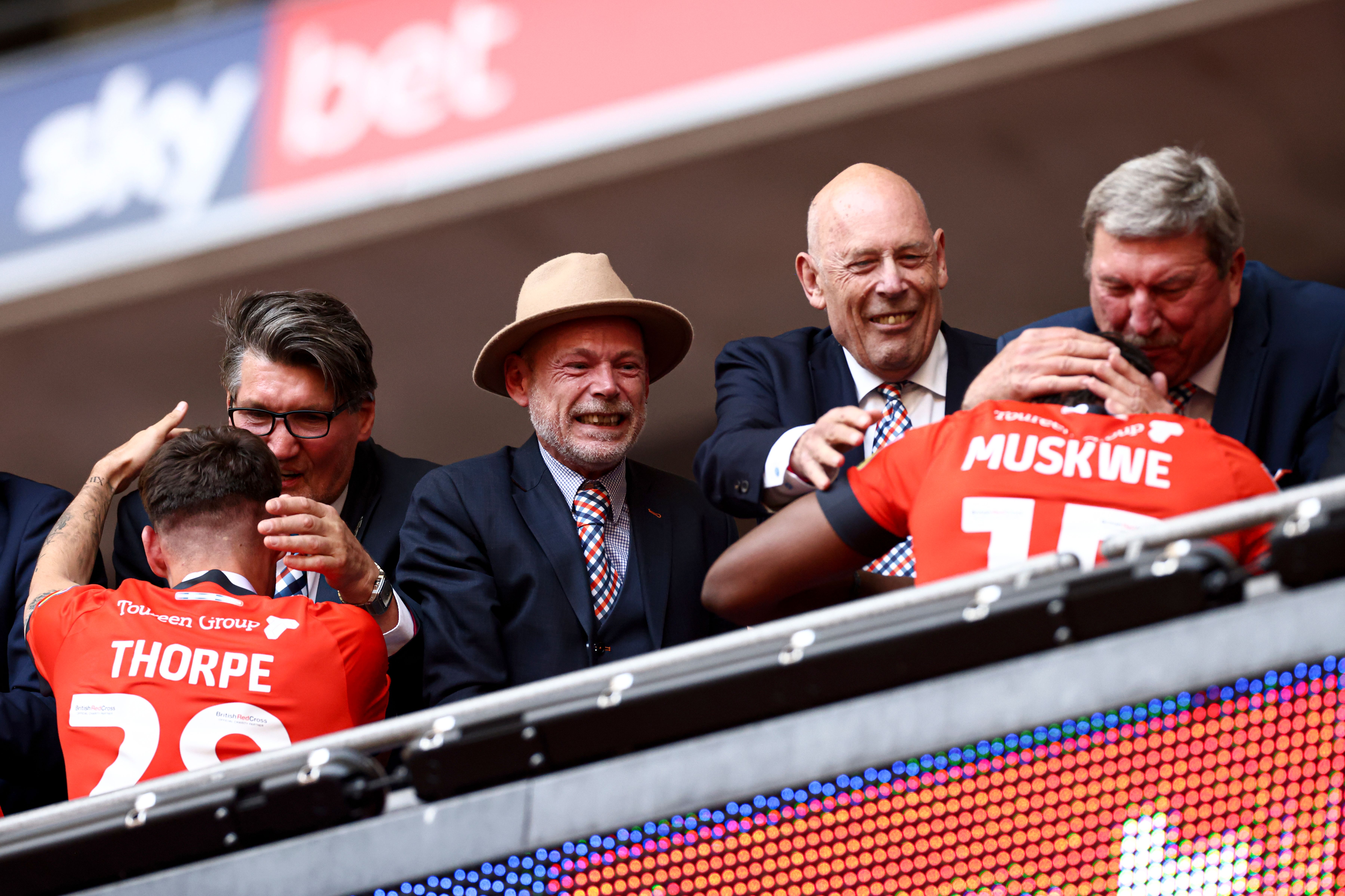 Stephen Browne, second from the left in the hat, celebrates in the Royal Box at Wembley after the Hatters win promotion to the Premier League.
