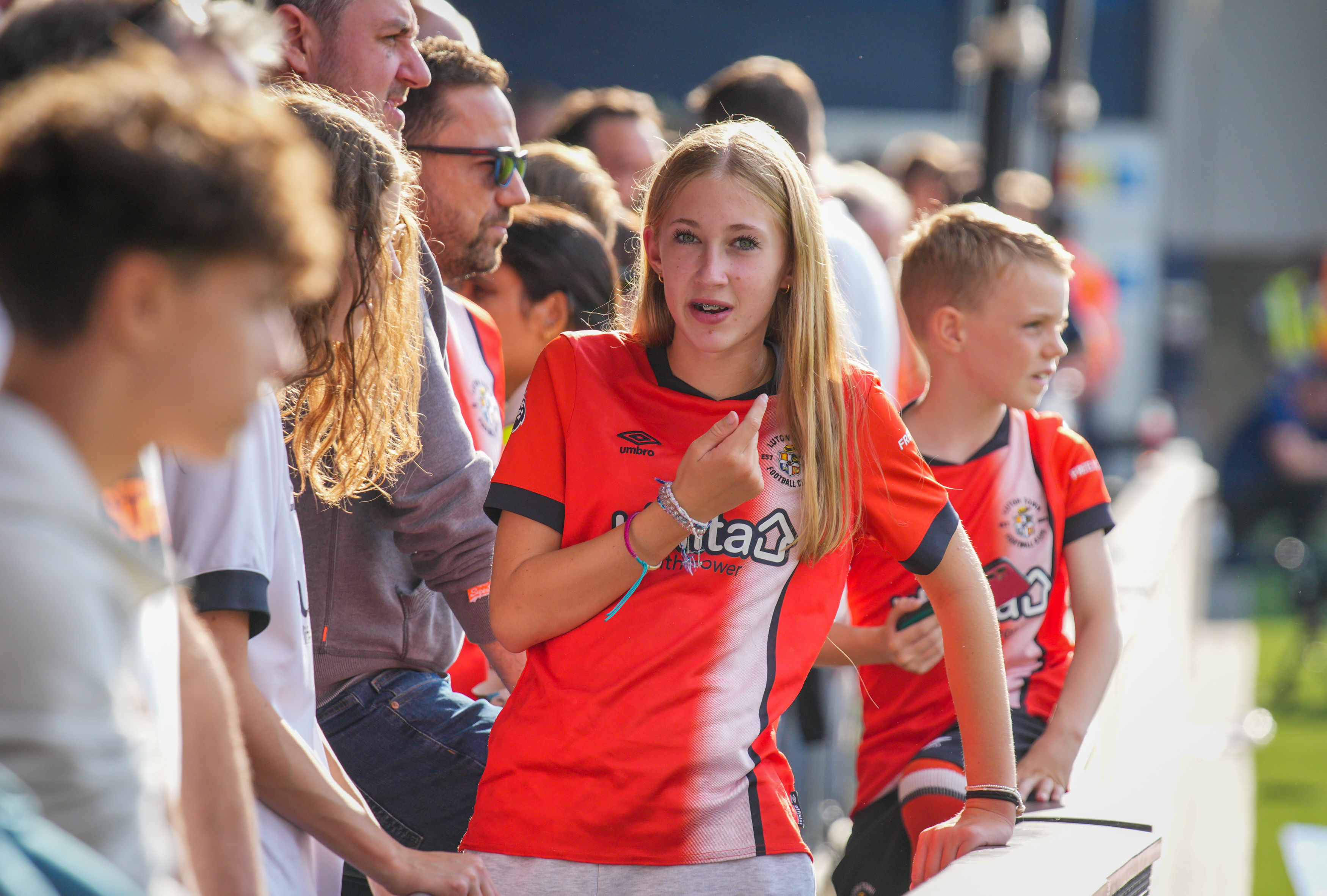Two young Luton Town supporters wear their orange home shirts at Kenilworth Road.