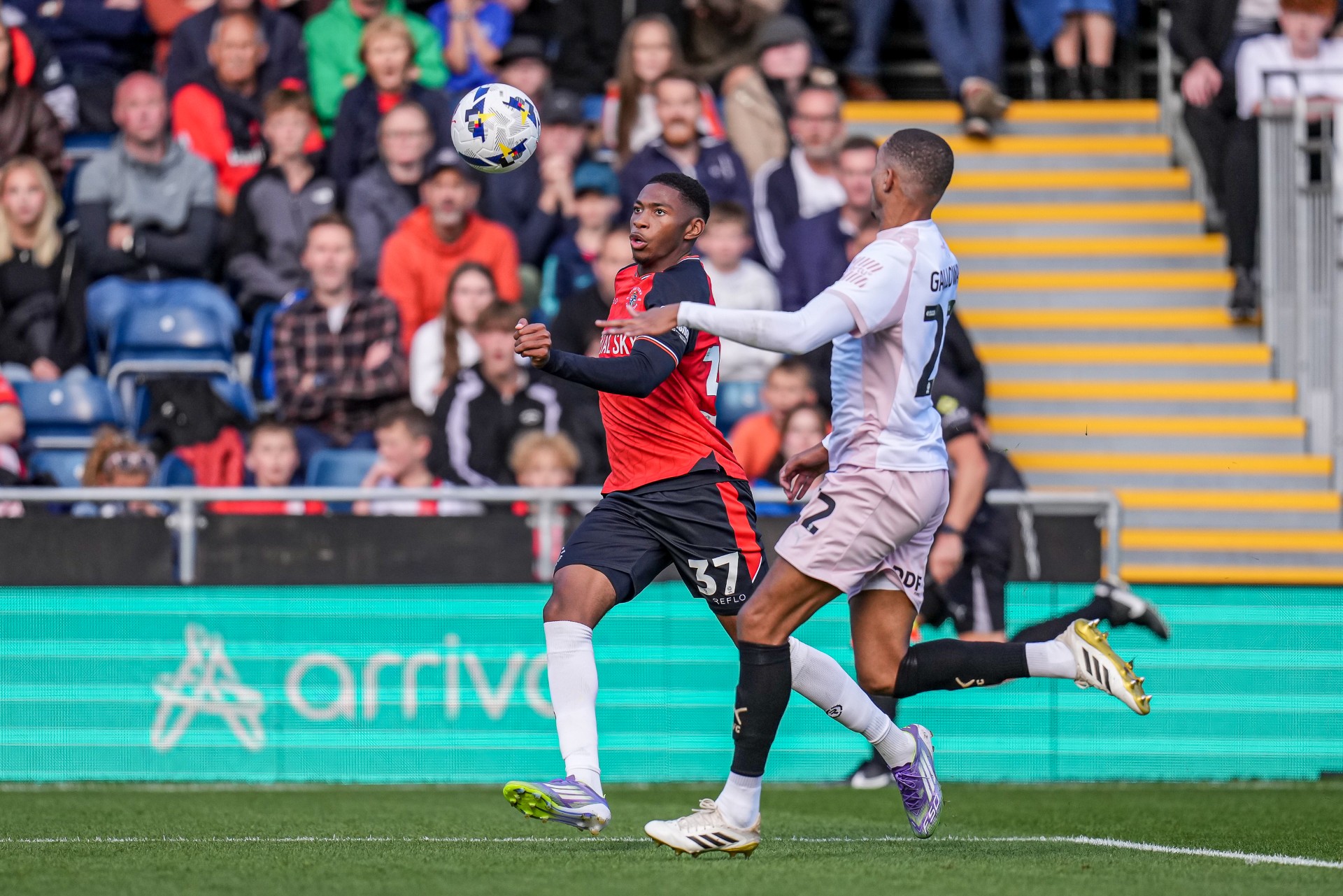 Hatters midfielder Zack Nelson in action at Kenilworth Road in front of the LED boards showing the Arriva logo