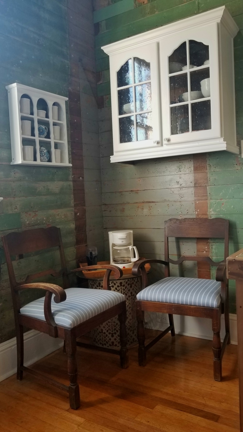 Small sitting area with the main living room with refinished chairs and cabinetry