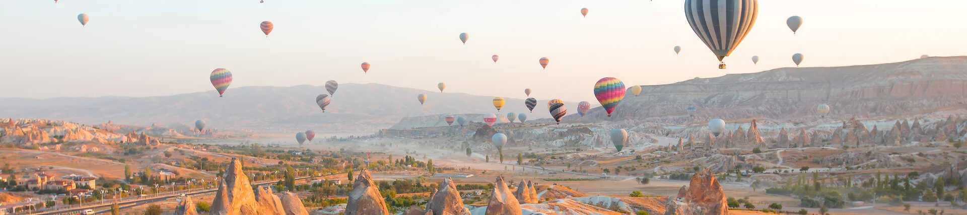 Heißluftballons fliegen über die Tuffsteinlandschaft von Kappadokien, Türkei.