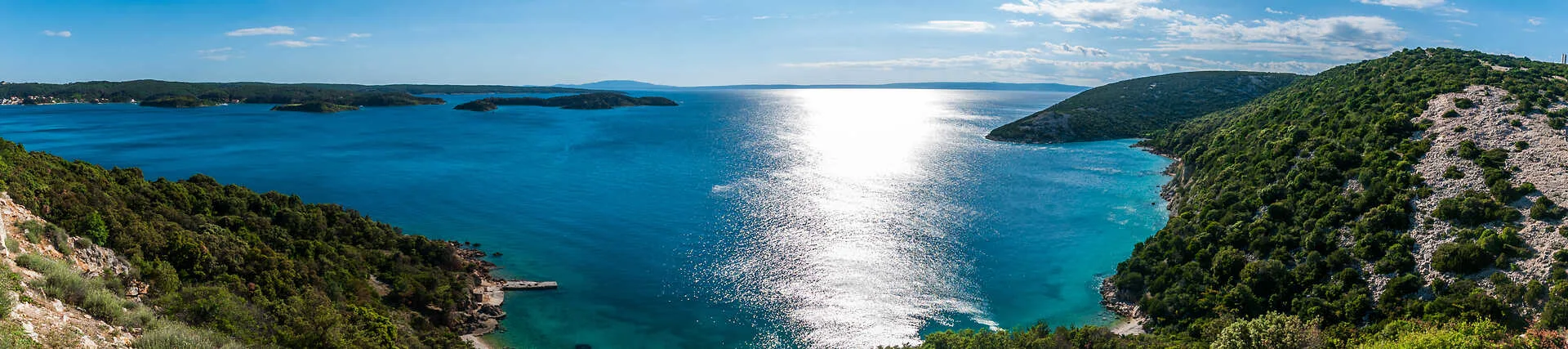 Kroatische Küste mit blauem Wasser und Klippen am Meer.