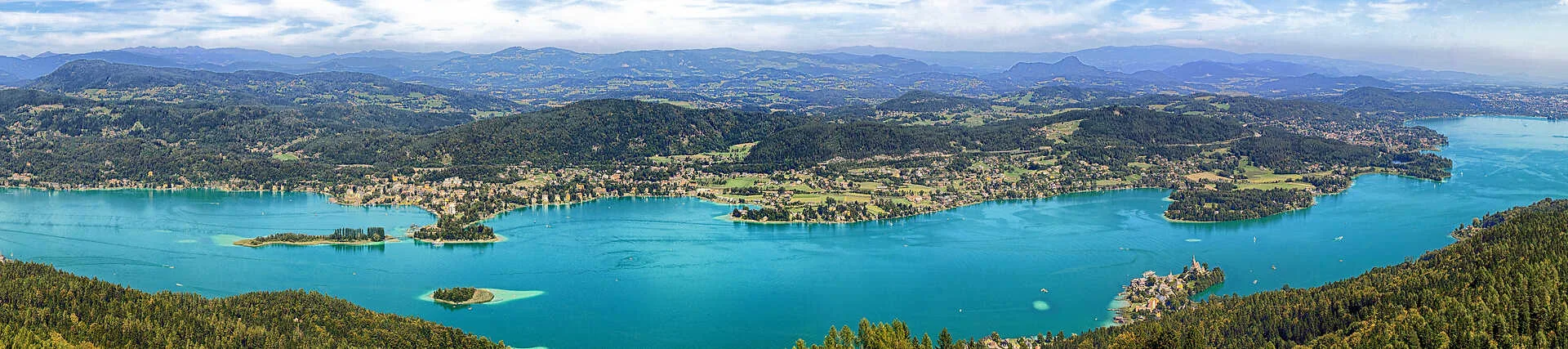 Wörthersee in Österreich mit Bergpanorama und klarem Wasser.
