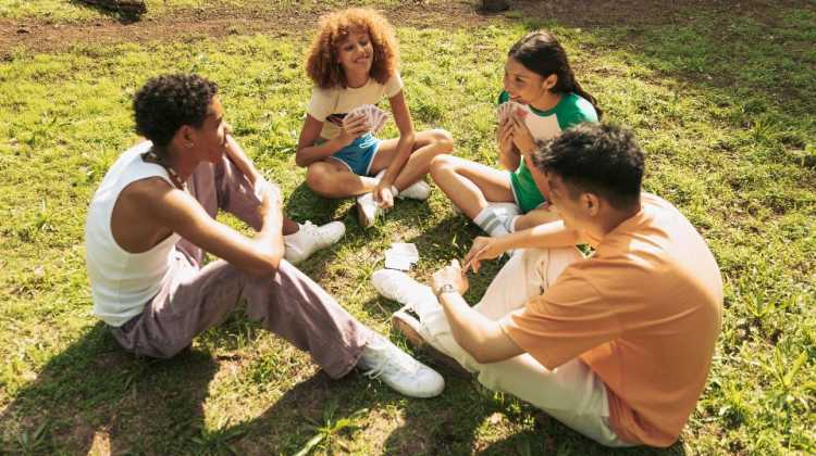 military kids making new friends after a move, playing cards together