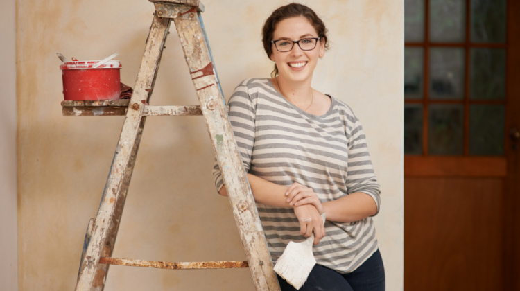 woman painting with ladder