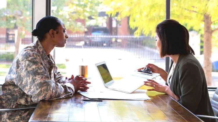 female service member in uniform discussing something with a female mortgage lender