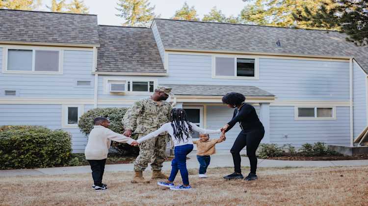military family in front of a home, showing resilience during PCS moves