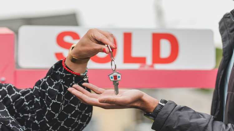 Two hands exchanging house keys in front of a sold sign.
Photo by: RODNAE Productions on Pexel