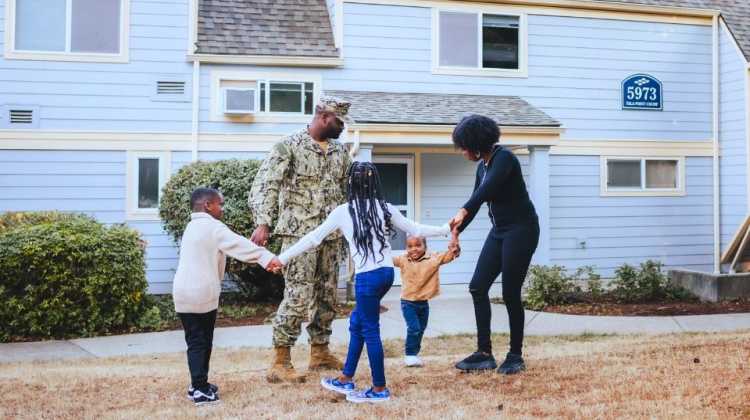 Military family of 5 dancing and laughing outside of their home