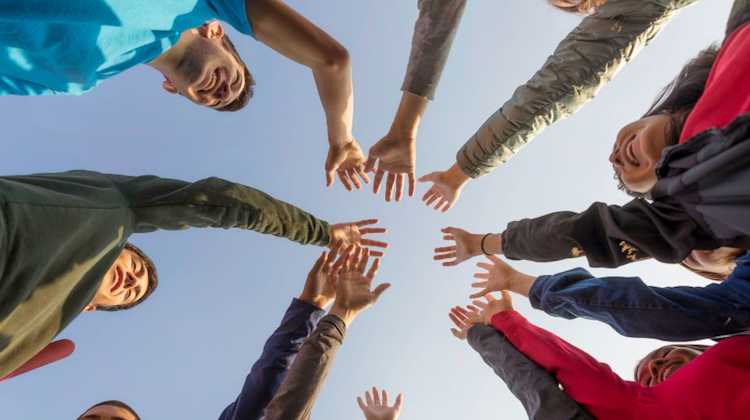 young adults do a group cheer or high five, since they have found community after a PCS move